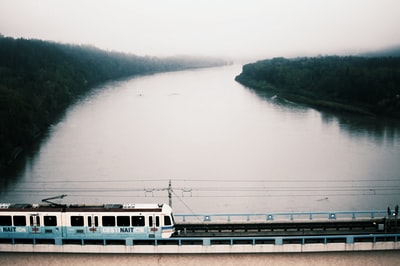 白天，白色列车在河上的桥上行驶